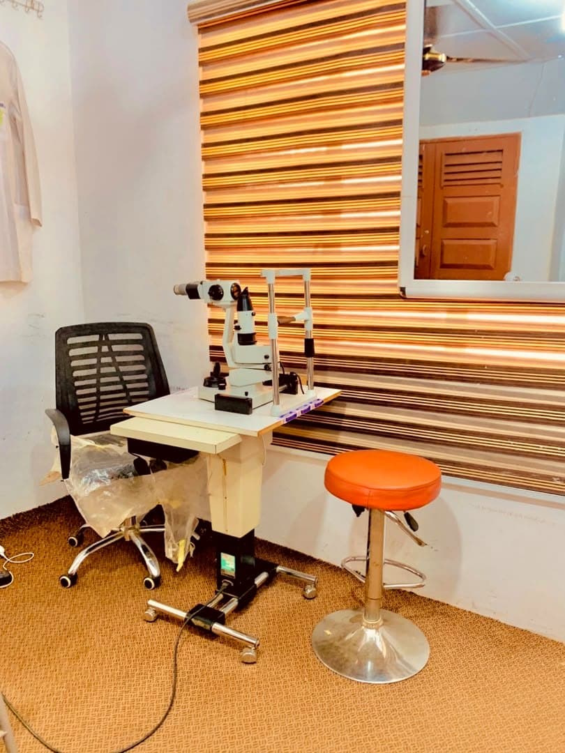 A calm slit-lamp consultation room with an examination chair at God First